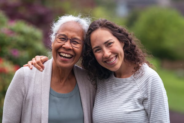 Two women smiling together in a garden