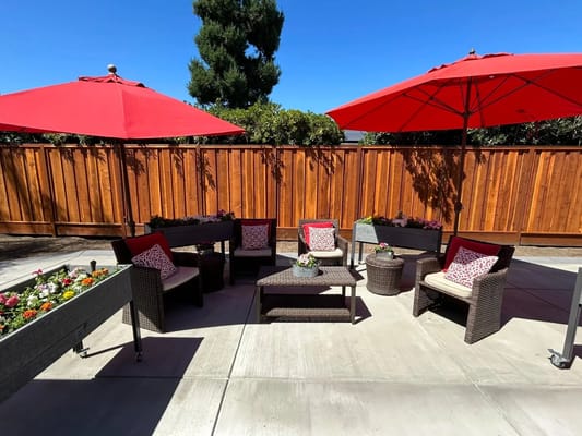 Outdoor seating area with red umbrellas and flower planters