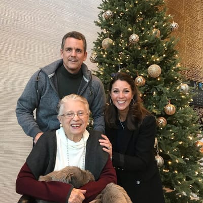 Residents and staff celebrating by a Christmas tree