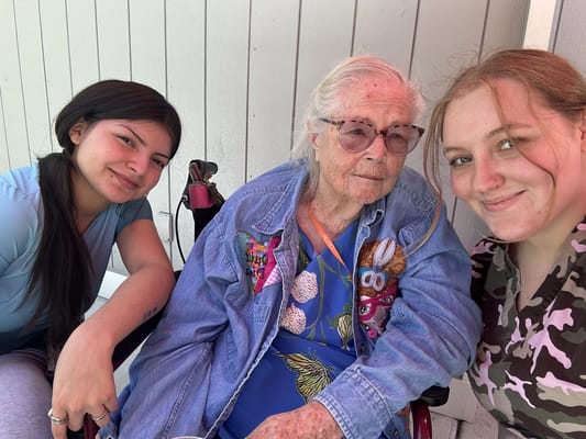Two staff members with a resident outdoors
