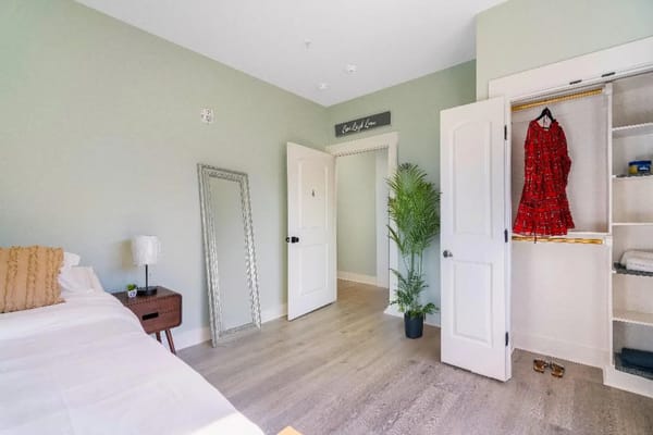 Brightly decorated private resident room with a bed and wardrobe