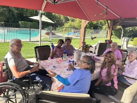 Residents and staff enjoying a craft activity outdoors