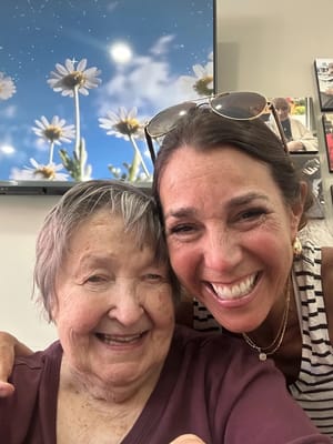 Two smiling women posing for a selfie indoors