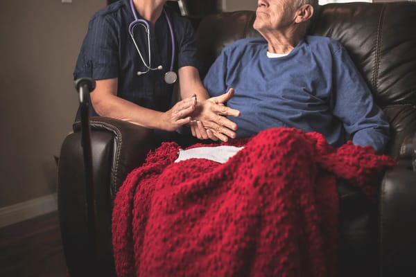 A caregiver interacting with a senior resident in a living room