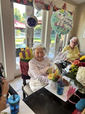 A resident celebrating with birthday decorations and fruit basket