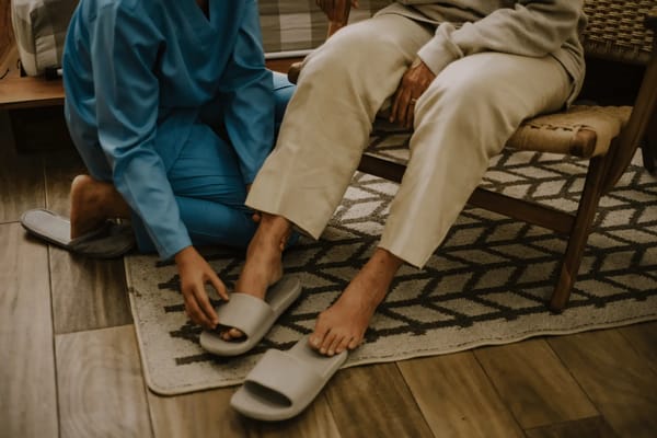 Caregiver helping a resident with slippers