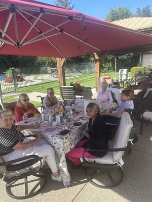 Residents enjoying a crafting activity outdoors under a gazebo