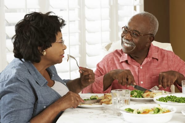 Two residents enjoying a meal together at a dining table