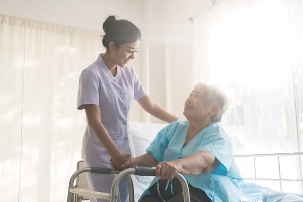 Caregiver assisting an elderly resident in a bright room