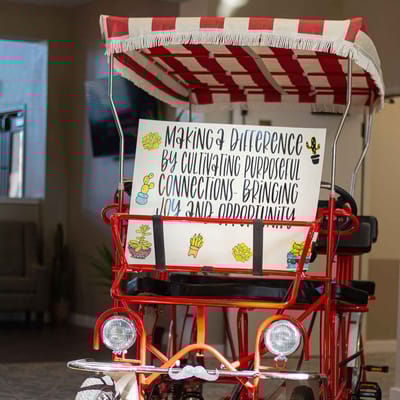Colorful bicycle cart with a sign indoors