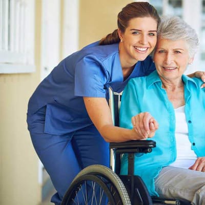 Nurse with a resident in a wheelchair outdoors
