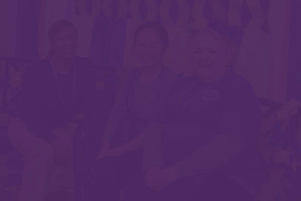 Residents and staff smiling together in a common area