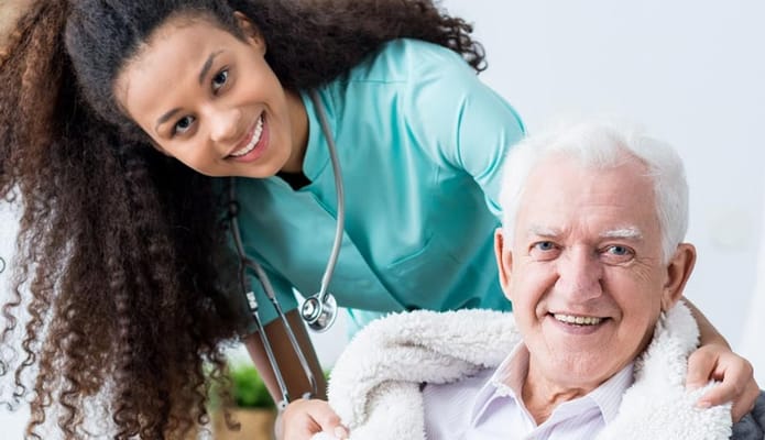 A caregiver smiling with a senior resident
