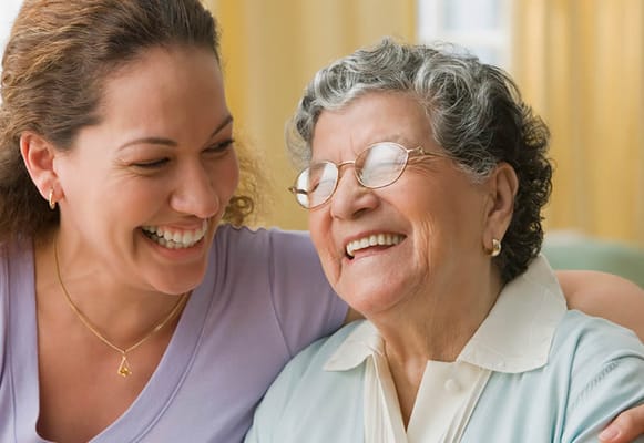 A caregiver and resident sharing a joyful moment
