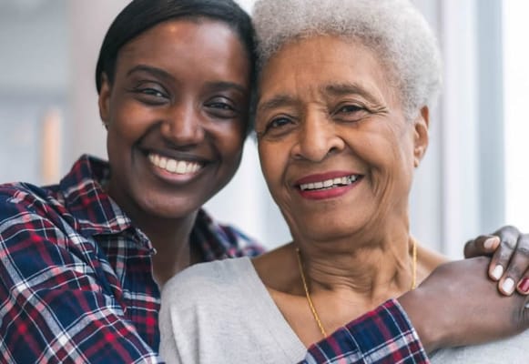 A staff member and resident smiling together