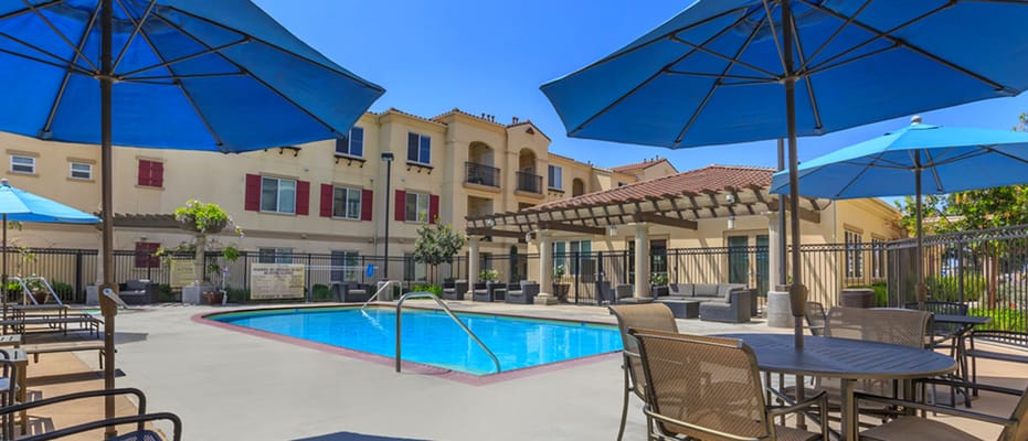 Swimming pool area with lounge chairs and umbrellas