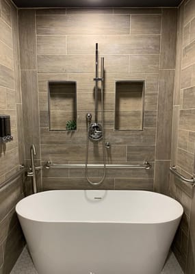 Modern bath with a freestanding tub and tiled walls
