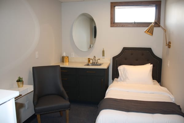 Well-furnished private resident room with a bed and chair