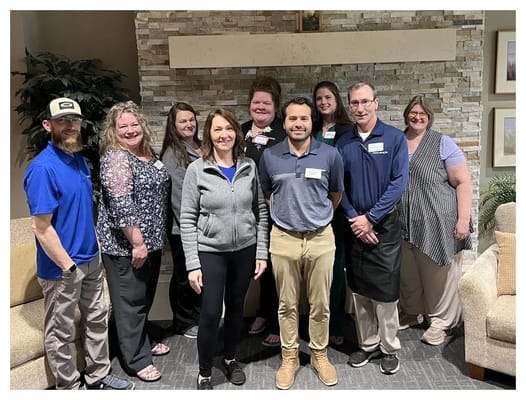 Staff members posing together in a common area