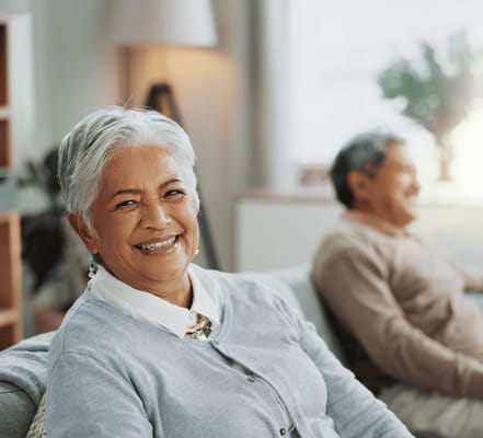 A senior woman smiling in a cozy interior setting