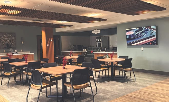 Bright dining area with tables and a TV