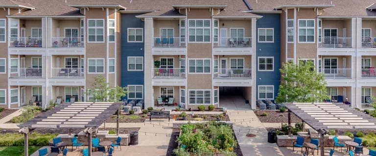 Exterior view of a senior living facility with gardens