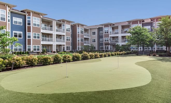 Outdoor putting green with surrounding residential buildings