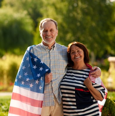 Residents smiling together outdoors with a flag