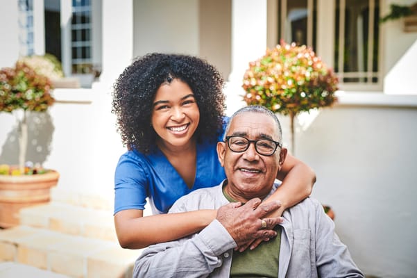 A staff member happily interacting with a resident outdoors