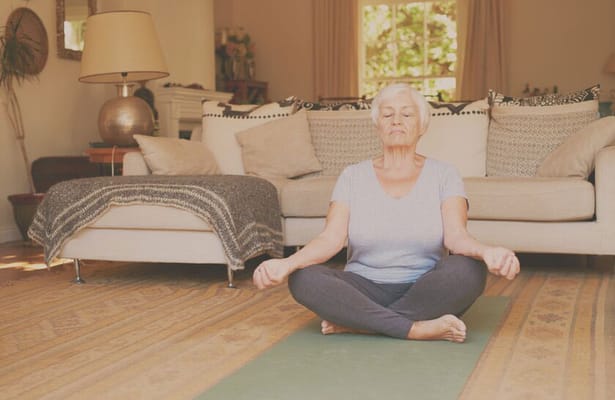 Senior woman meditating in a cozy living room