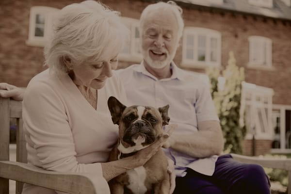 A couple with a dog in a garden setting