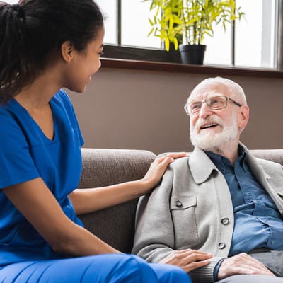A caregiver interacting warmly with a senior resident