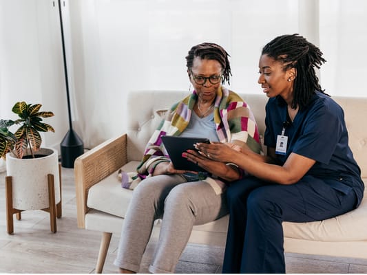 Caregiver assisting a resident with a tablet