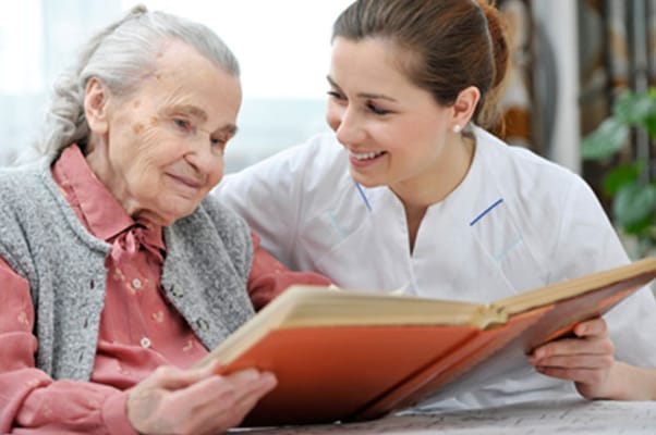 Staff reading with a resident in a cozy setting