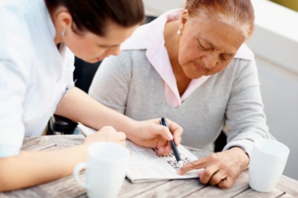 Caregiver assisting a resident with a puzzle