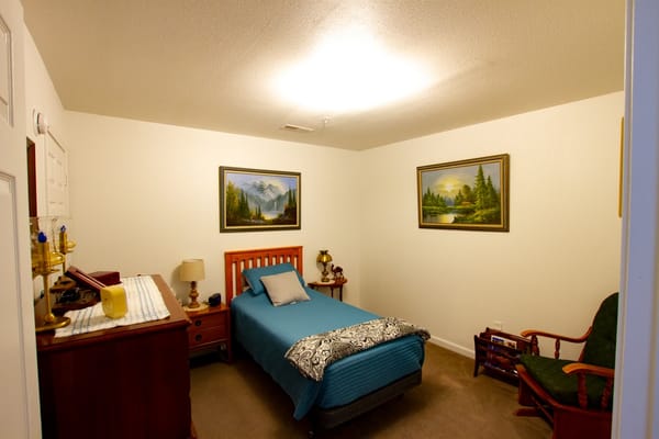 Cozy resident room with bed and paintings
