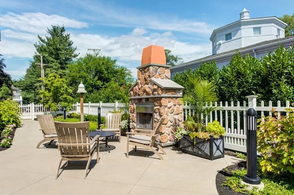 Outdoor seating area with a fireplace and greenery