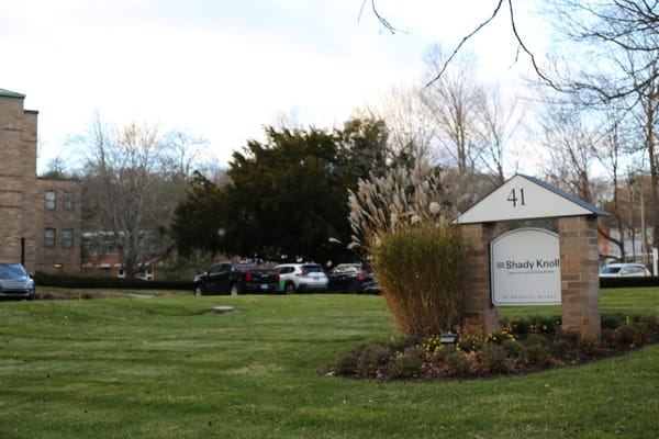 Sign of Shady Knoll Center in a grassy area