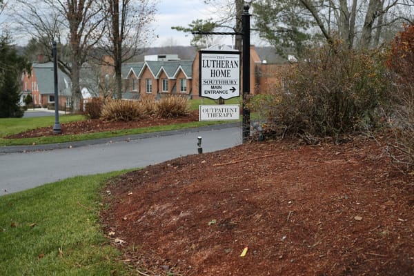 Sign for the Lutheran Home indicating main entrance and outpatient therapy services.