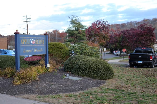 Sign for Apple Rehab Laurel Woods facility with landscaped surroundings