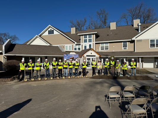 Construction team posing in front of the facility