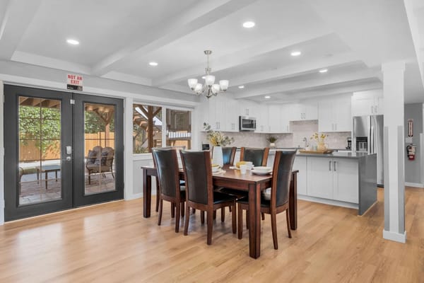 Bright dining area with large wooden table and chairs