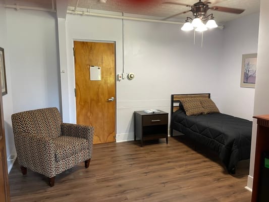 Simple room interior with a bed and armchair