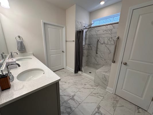Modern bathroom with marble tiles and grab bars