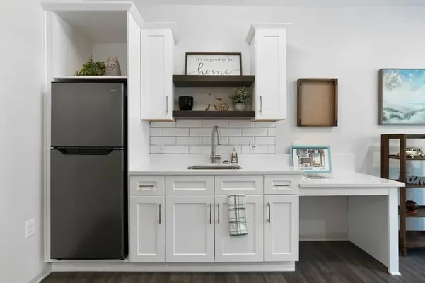 Modern kitchenette with white cabinets and decor