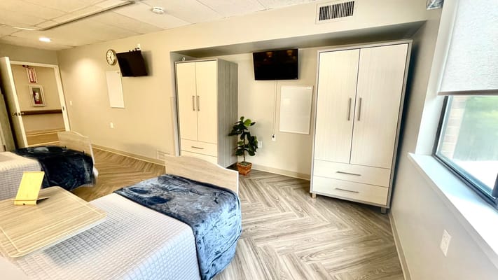 Interior view of a resident room with beds and furniture