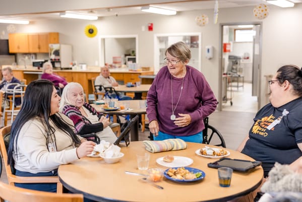 Residents enjoying a meal and conversation in the dining area