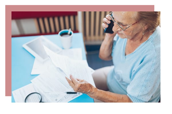 Senior woman on the phone reviewing documents