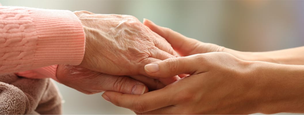 Caregiver holding an elderly person's hands