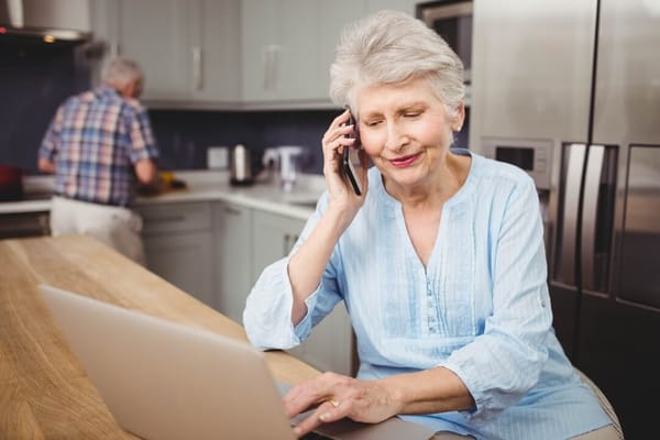 Senior resident using a laptop while on the phone